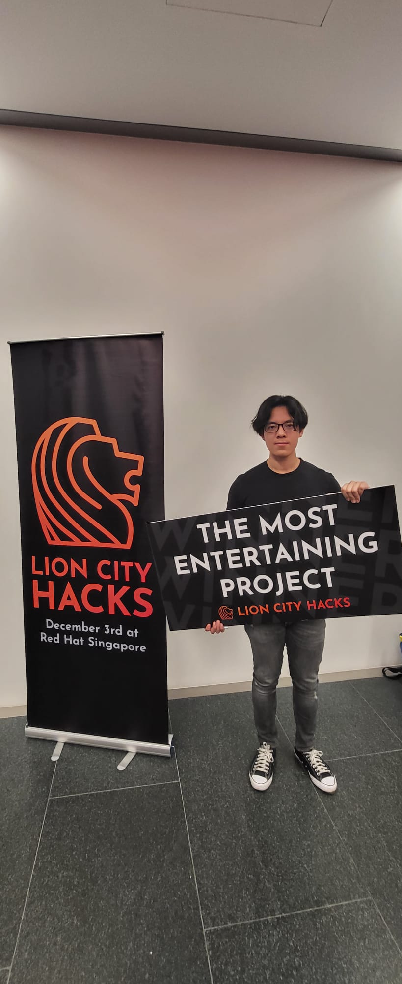 Holding the Most Entertaining Project winner board at Lion City Hacks